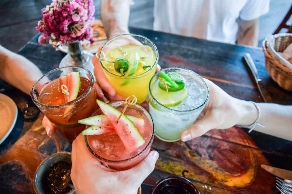Four people clinking their decorative cocktails together